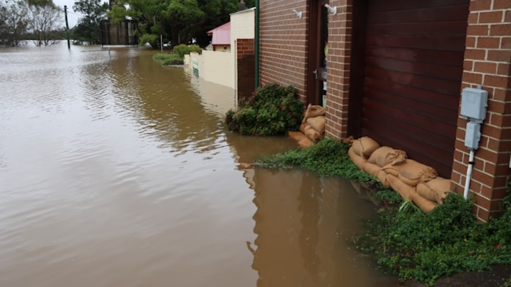 A photo showcasing a flooded area and sandbags blocking an area