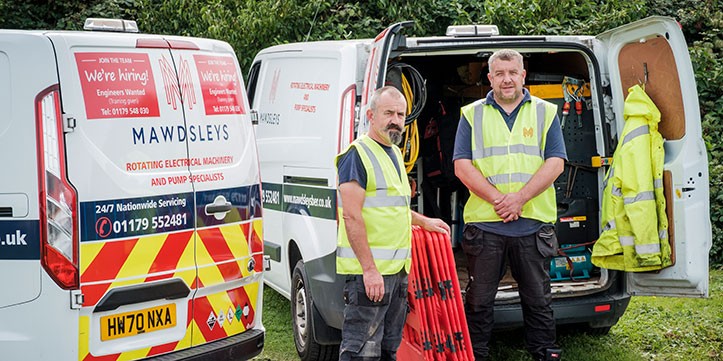 2 engineers in hi vis jackets in front of two Mawdsleys Vans