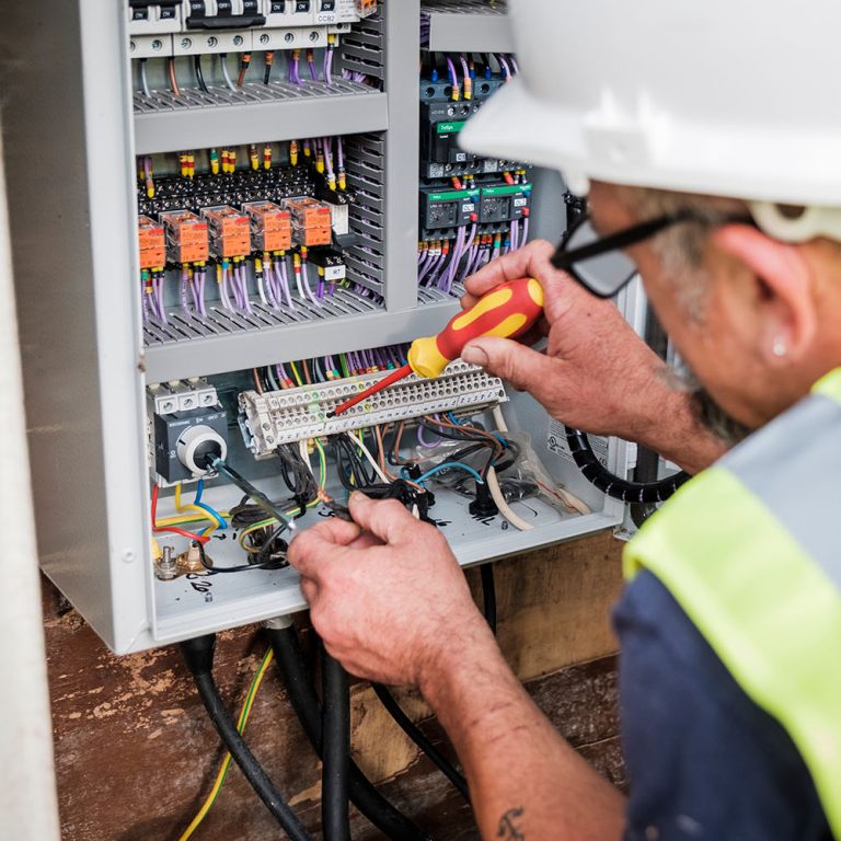 An image of an engineer fixing a control panel