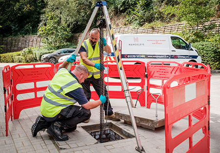 An image demonstrating two of our engineers fixing a sewage pump